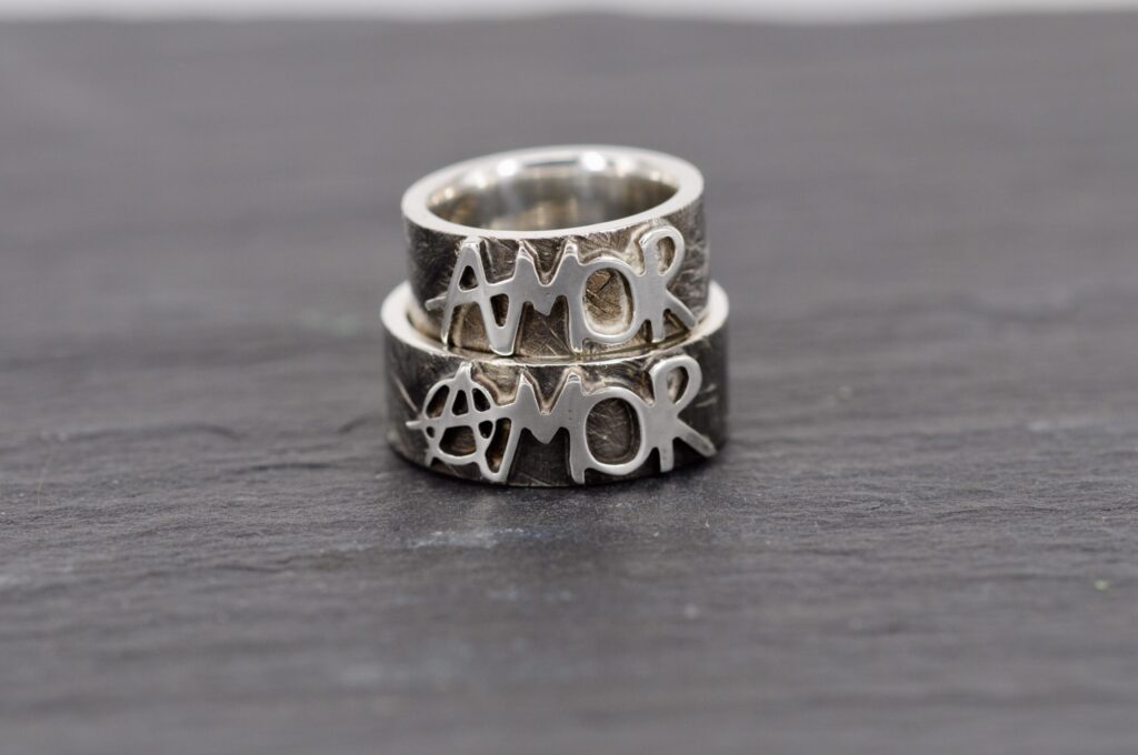 Handgefertigte Eheringe aus Silber mit Amor-Schriftzug von der Goldschmiede Stephanie Berger.