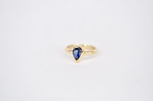 Handgefertigter Ring aus Gelbgold von Goldschmiede Stephanie Berger mit einem im Tropfenschliff gefassten, blauen Saphir.
