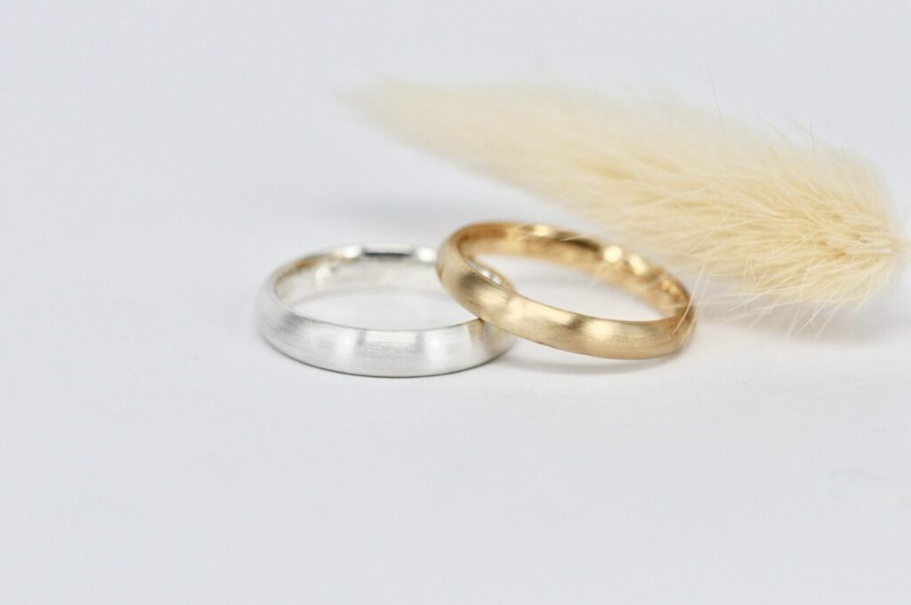 Trauring-Paar von Goldschmiede Stephanie Berger: schlichter Herrenring aus Silber und eleganter Damenring aus warmem Roségold.
