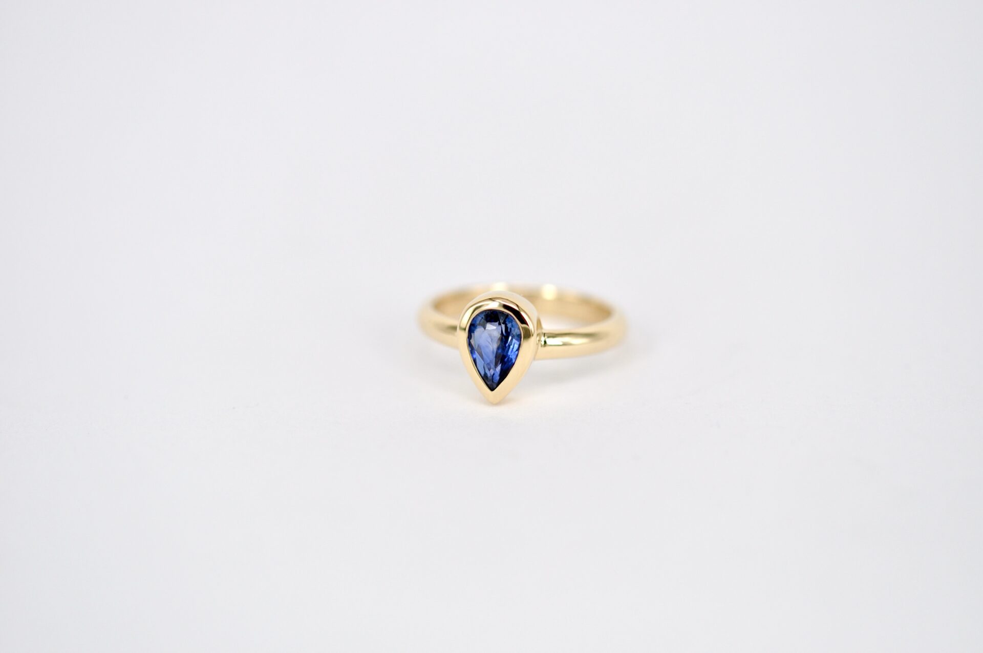 Eleganter Verlobungsring von Goldschmiede Stephanie Berger mit einem tiefblauen Saphir im Tropfenschliff (Pear Cut).