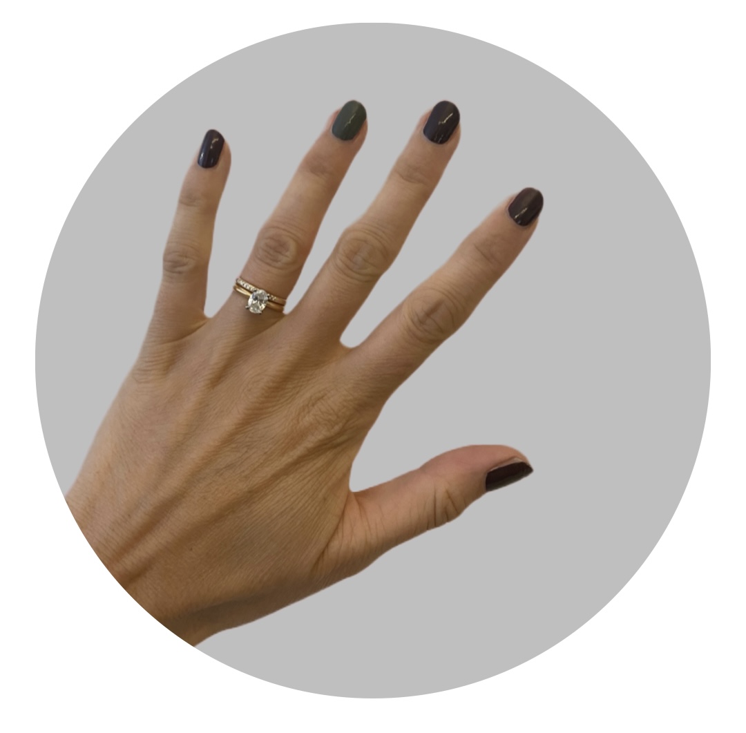 Tragebeispiel: Handgefertigter Verlobungsring aus Gold von Goldschmiede Stephanie Berger mit einem funkeldem ovalen 1-Karat-Diamanten an der Hand getragen.