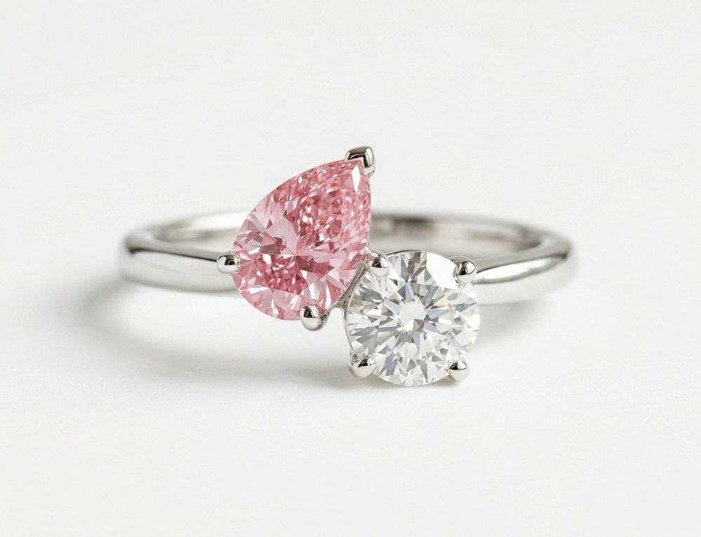Eleganter Toi-et-Moi-Ring mit zwei nebeneinander gefassten Edelsteinen auf einer geschwungenen Ringschiene